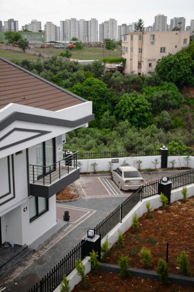 Contemporary houses in Adana near a green landscape with urban skyline.